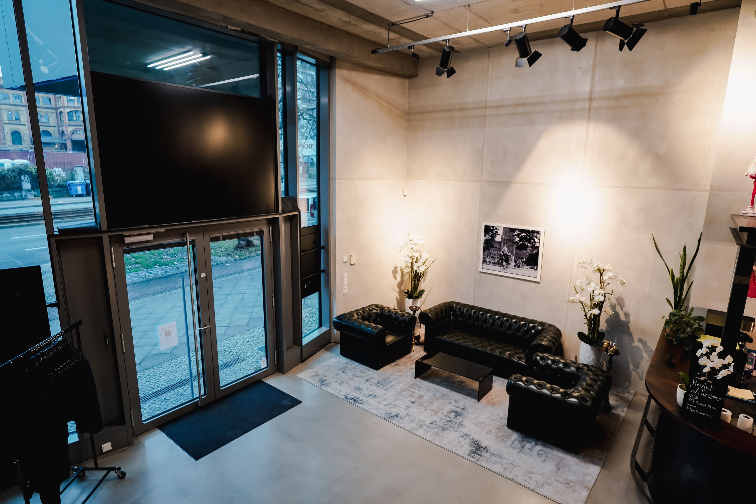 Entrance area with glass door, Chesterfield sofas and orchids