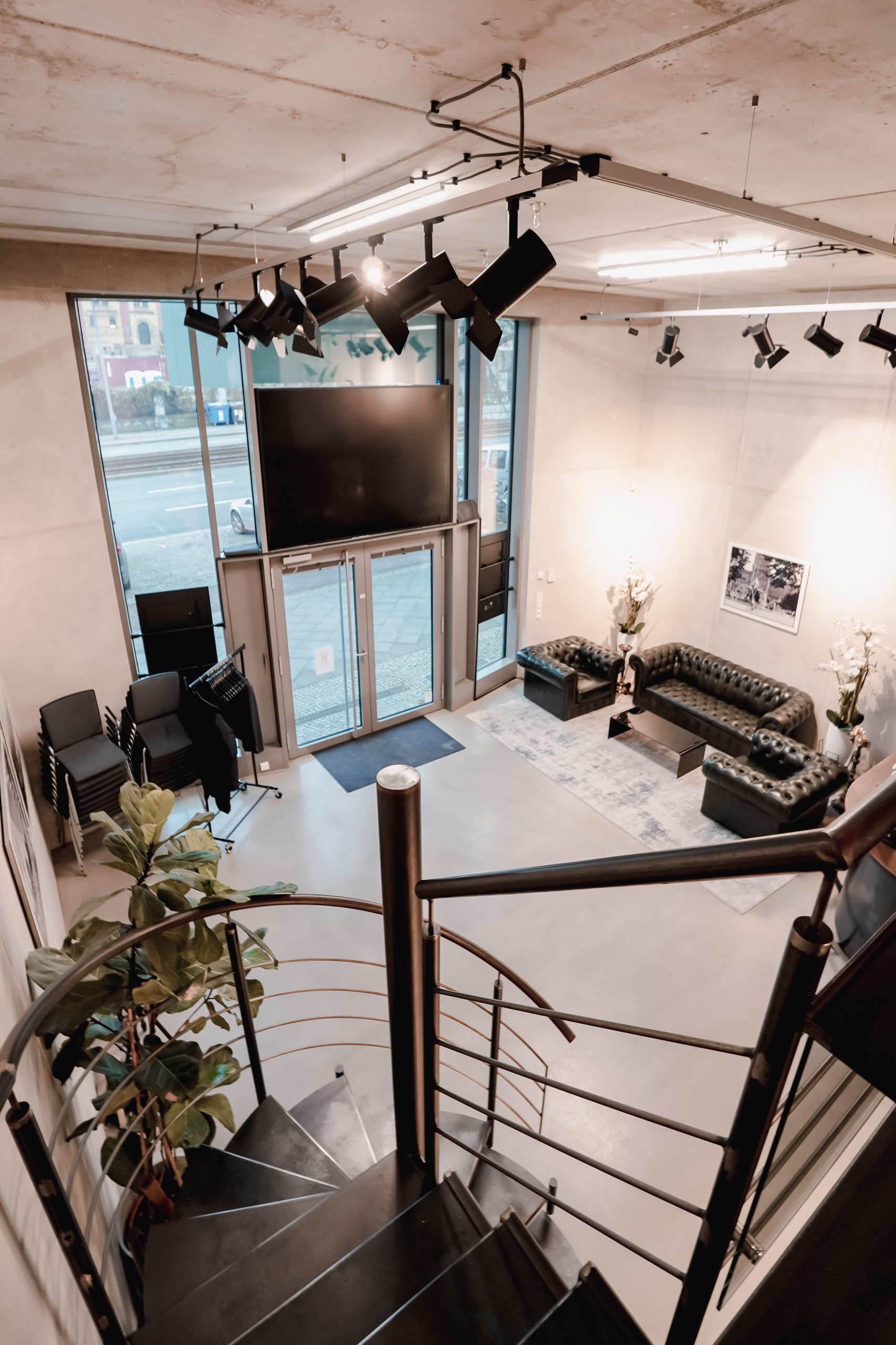 Reception area with entrance door, Chesterfield sofas and screen, seen from the gallery
